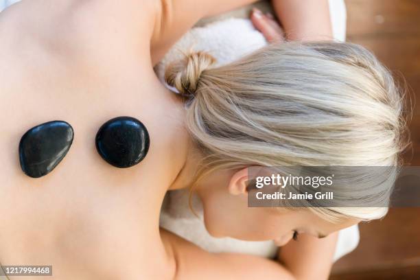 woman enjoying hot stone massage - lastone terapi bildbanksfoton och bilder