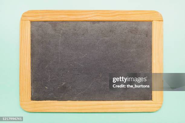 high angle view of a blank chalkboard on turquoise background - ardoise photos et images de collection