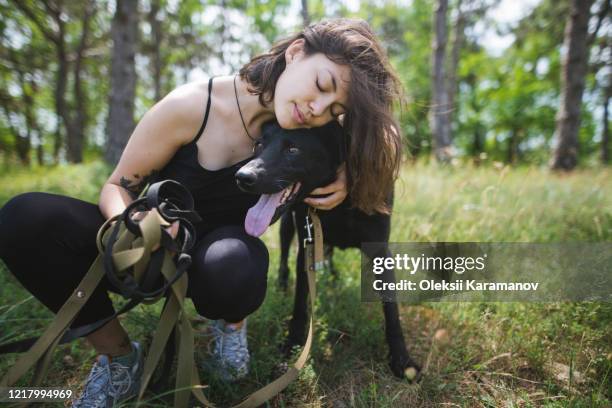 young woman hugging dog from animal shelter in forest - simferopol stock pictures, royalty-free photos & images