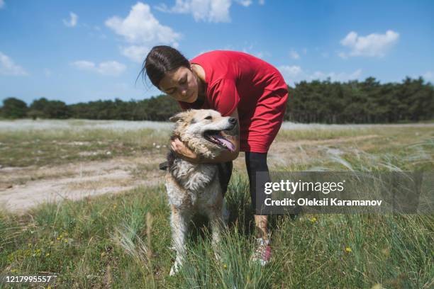 young woman walking dog from animal shelter - simferopol stock pictures, royalty-free photos & images