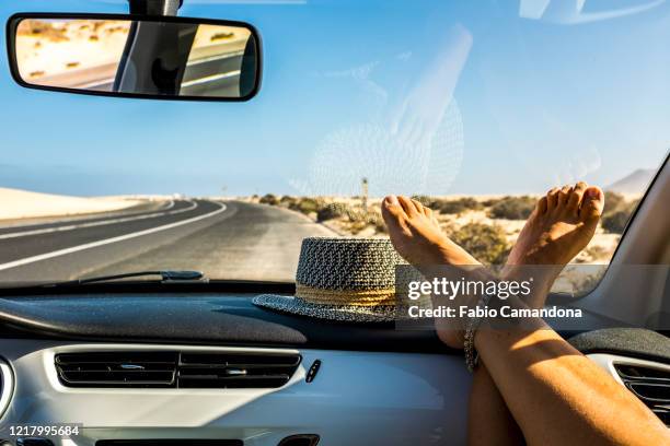 female feet on dashboard during road trip - modern traveling stockfoto's en -beelden