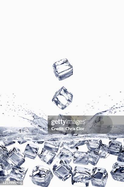 ice cubes falling into water - ice cube stock-fotos und bilder