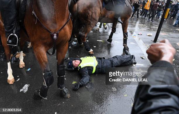 Mounted police officer lays on the road after being unseated from their horse, during a demonstration on Whitehall, near the entrance to Downing...