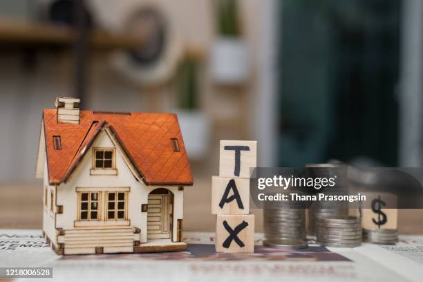 tax text written on wooden block with stacked coins - testamento foto e immagini stock