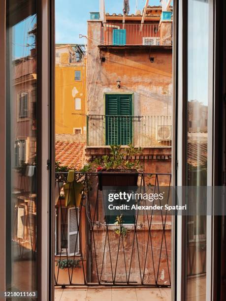 street seen through an open balcony door in rome, italy - village home indoor stock-fotos und bilder