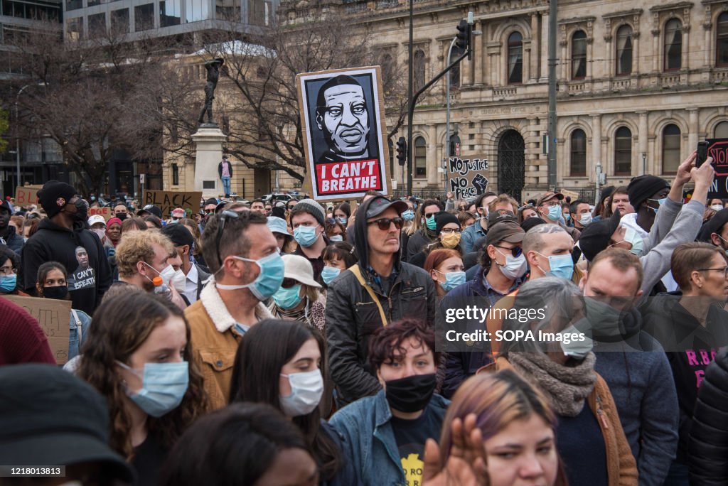 Protesters gather while wearing face masks during the...