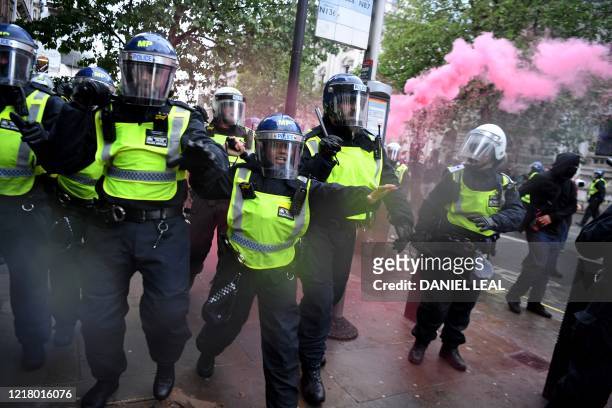 Police officers in riot gear shout to protestors near Downing Street, in central London on June 6 during a demonstration organised to show solidarity...