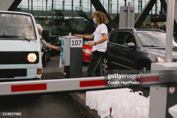 Staff gives instructions to the driver during the opening of drive in Gallery's show "Nachtbroetchen 2.0" at Cologne airport parking lot amid the...