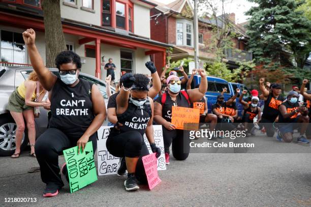 Protesters take a knee and raise their firsts during an anti-racism march on June 6, 2020 in Toronto, Canada. This is the 12th day of protests since...