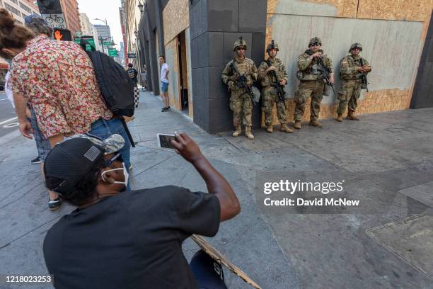 Protester photographs National Guard troops as people continue to demonstrate over the killing of George Floyd despite the dangers of the widening...