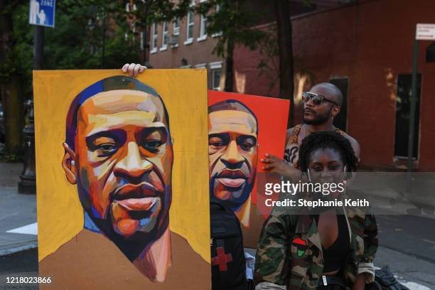 Protesters take a break and pose for a photo with two portraits of George Floyd on June 6, 2020 in New York City. This is the 12th day of protests...