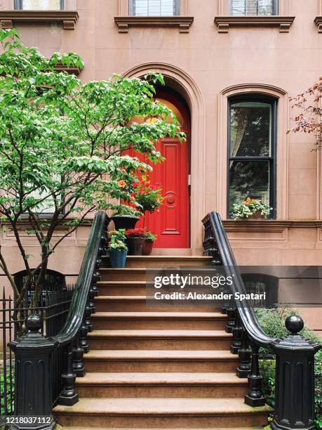 red door of a residential brownstone townhouse in west village, new york city, usa - terraced houses stock pictures, royalty-free photos & images