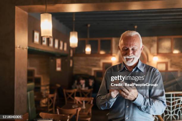 joyful businessman communicating on smartphone - senior romance stock pictures, royalty-free photos & images