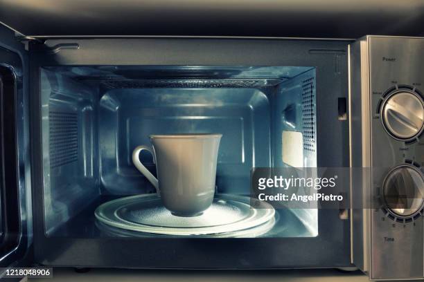 at home still life - a cup inside a microwave - microwave dish stock pictures, royalty-free photos & images