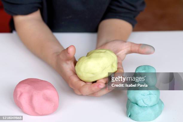 child playing with play dough - klei stockfoto's en -beelden