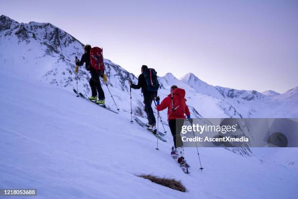 backcountry skiers ascend mountain - back country skiing stock pictures, royalty-free photos & images