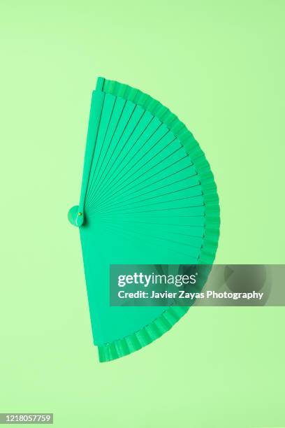 green folding fan over green background - leque - fotografias e filmes do acervo