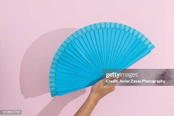 blue folding fan over pink background - fächer stock-fotos und bilder