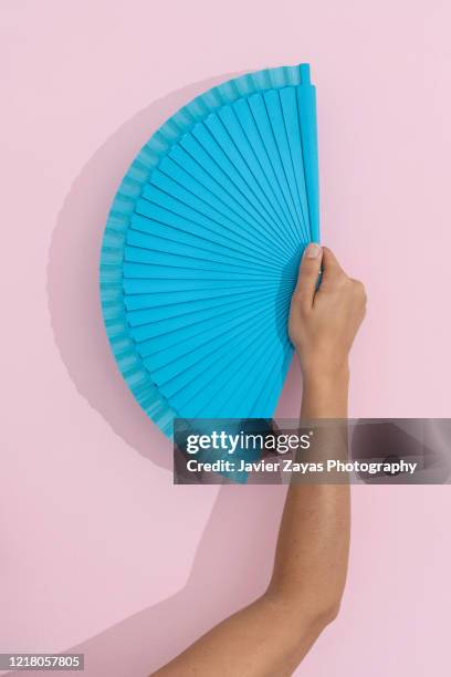 blue folding fan over pink background - spanish culture fotografías e imágenes de stock