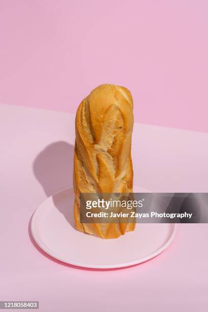 half loaf of bread on a pink plate - half fotografías e imágenes de stock