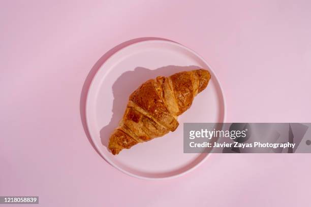 croissant on a pink plate - pink colour stockfoto's en -beelden