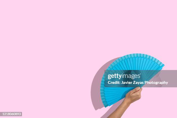 blue folding fan over pink background - éventail photos et images de collection