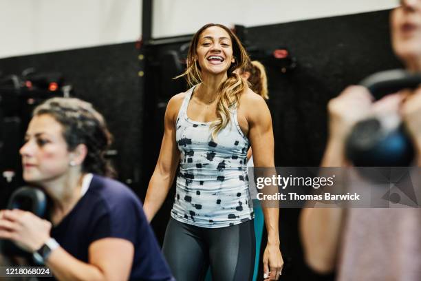 smiling gym owner leading womens fitness class - health coach stock pictures, royalty-free photos & images