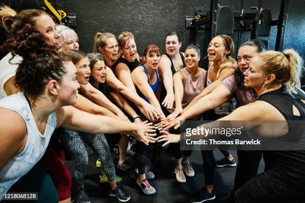 womens fitness class with hands together after workout in gym - fun team sport stock pictures, royalty-free photos & images