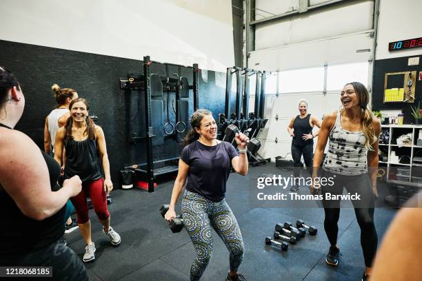 smiling woman singing with dumbbell during fitness class with friends - real life funny stock pictures, royalty-free photos & images