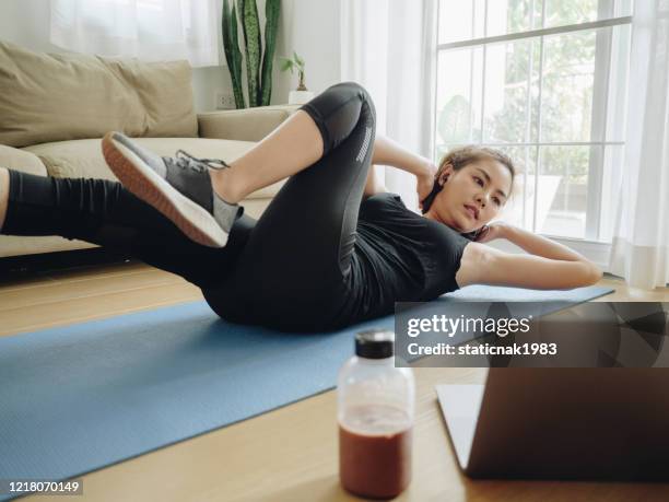 asian woman working out with laptop at home - strength training stock pictures, royalty-free photos & images