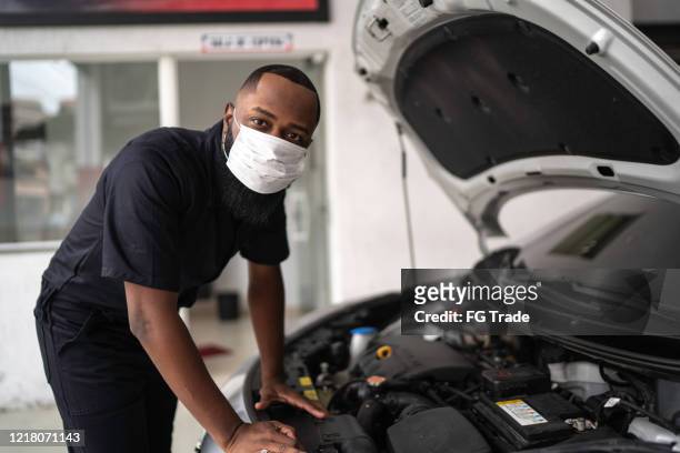 portrait of auto mechanic man with face mask at auto repair shop - small business mask stock pictures, royalty-free photos & images