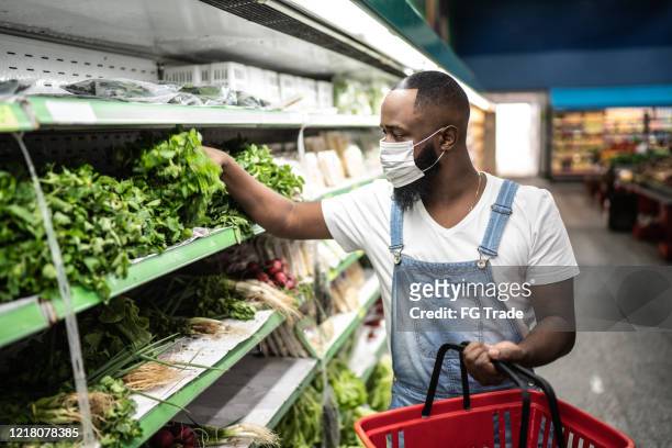 Man with face mask walking and shopping in supermarket