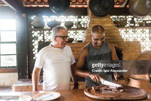 smiling men at brazilian barbecue - fathers day lunch stock pictures, royalty-free photos & images