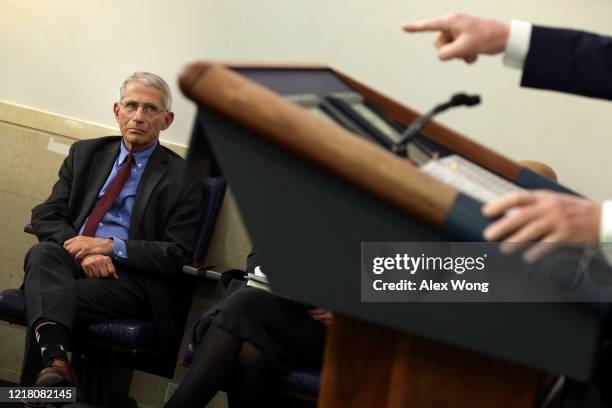 National Institute of Allergy and Infectious Diseases Director Anthony Fauci watches as U.S. President Donald Trump makes a point during the daily...