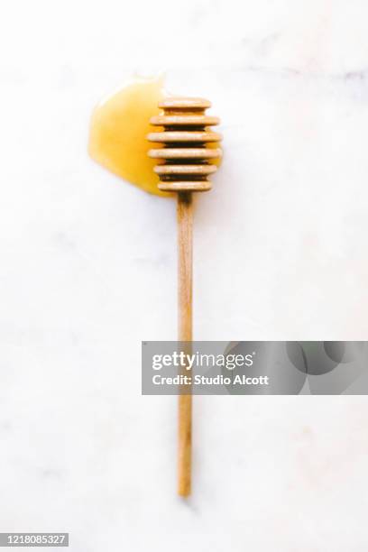 raw honey on a dipper - wooden stick stock pictures, royalty-free photos & images