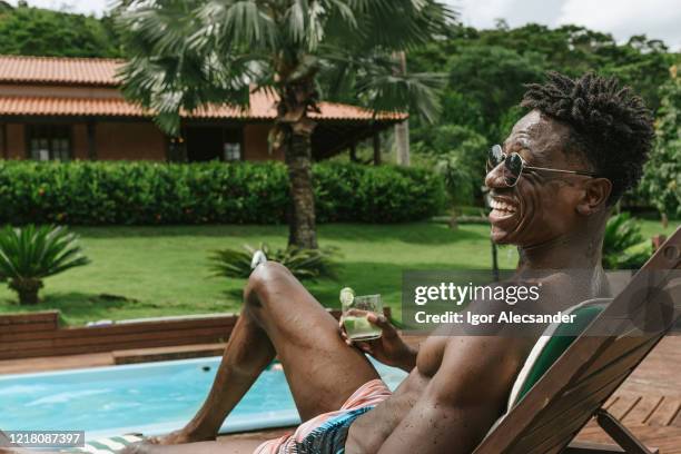 man sunbathing at home during summer - caipirinha stock pictures, royalty-free photos & images