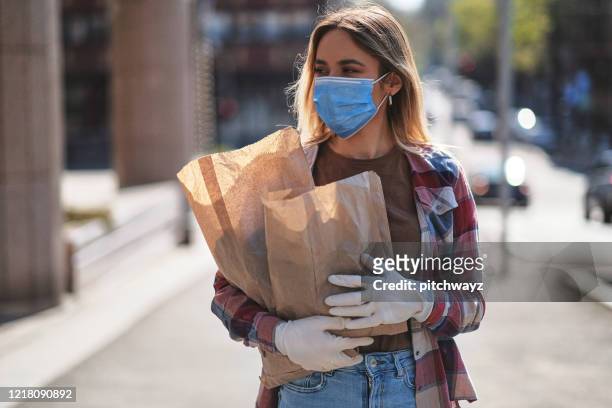 young woman on the street, during covid-19 pandemic - máscara de gripe imagens e fotografias de stock