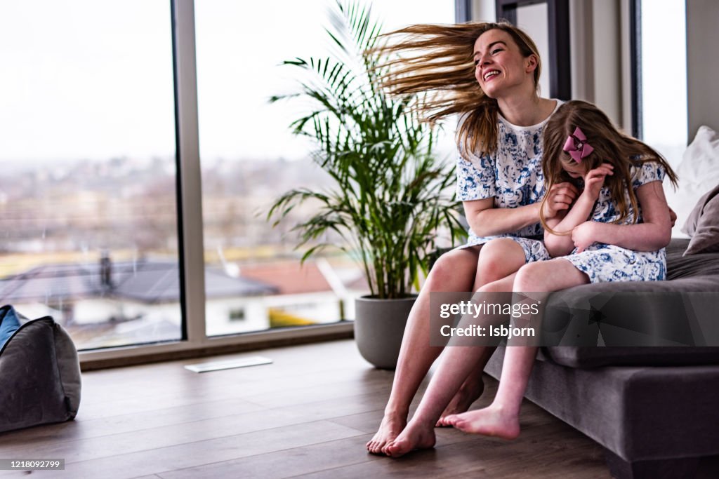 Happy mother tickling her daughter.