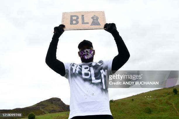 Protester holds a placard as they attend a demonstration in Edinburgh on June 7 organised to show solidarity with the Black Lives Matter movement in...