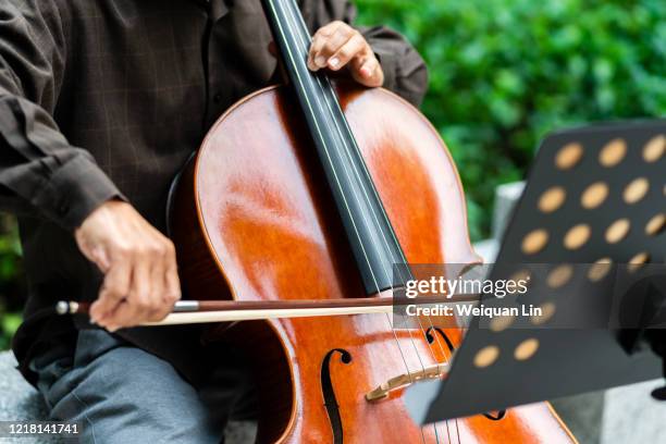 close-up of senior man playing cello - cellist stock pictures, royalty-free photos & images