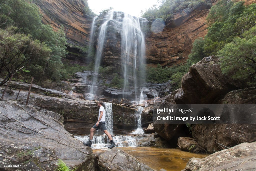 Man hiking across stream