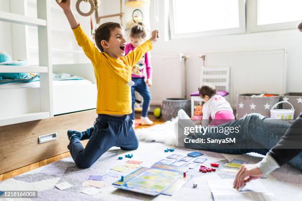 het spelen van de familie bordspel - bordspel stockfoto's en -beelden