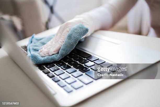 woman disinfects the laptop keyboard with spray - office cleaning stock pictures, royalty-free photos & images