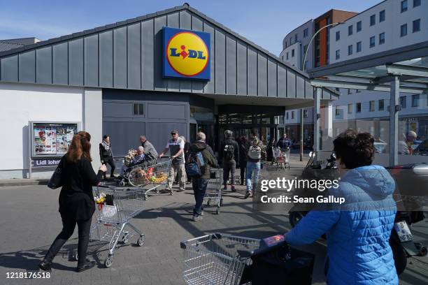 People wait in line socially-distanced to enter a Lidl supermarket during the coronavirus crisis on April 11, 2020 in Berlin, Germany. The number of...