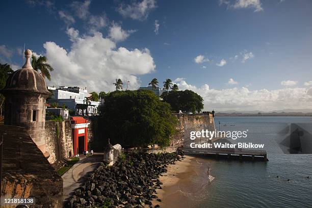 city walls by puerta de san juan gate and la forteleza, old san juan, san juan, puerto rico, december 2009 - la puerta de san juan stock pictures, royalty-free photos & images