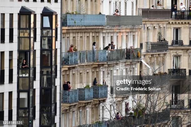 People applaud on their balconies at the neighborhood of "Gobelins" during the confinement of the French due to an outbreak of the coronavirus on...