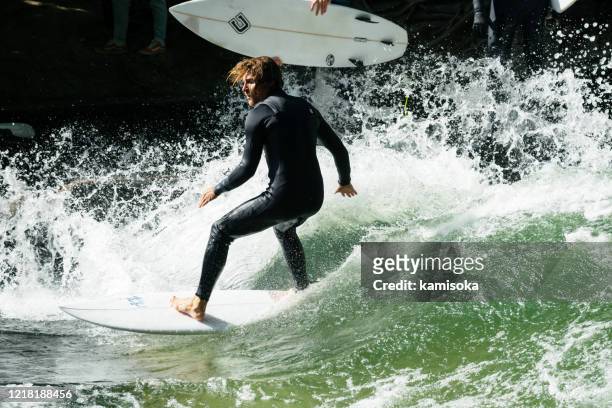 surfing man on the eisbach in munich, germany - munich surfing stock pictures, royalty-free photos & images