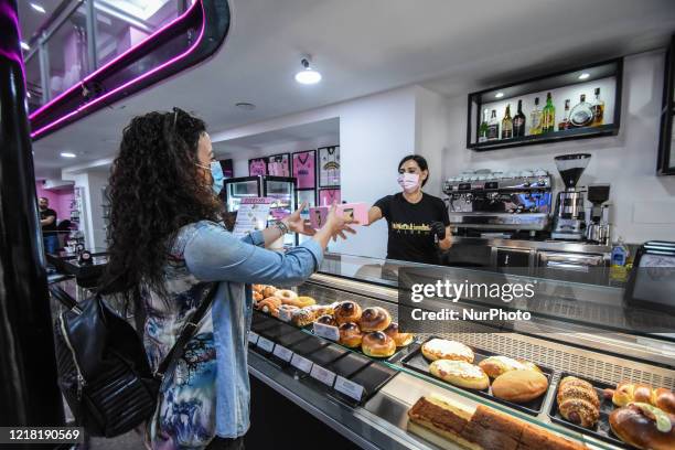 Bartender serves cake at a bar in Palermo, Italy, on May 4, 2020. With Phase 2 of the COVID-19 emergency, the people of Palermo returned to the...