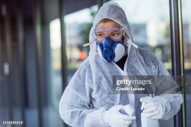 a female essential worker wearing a face mask during virus outbreak - clean suit stock pictures, royalty-free photos & images