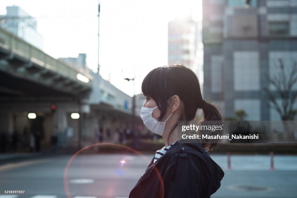 外科用マスクを着用したアジア女性のサイドビュー屋外肖像画
